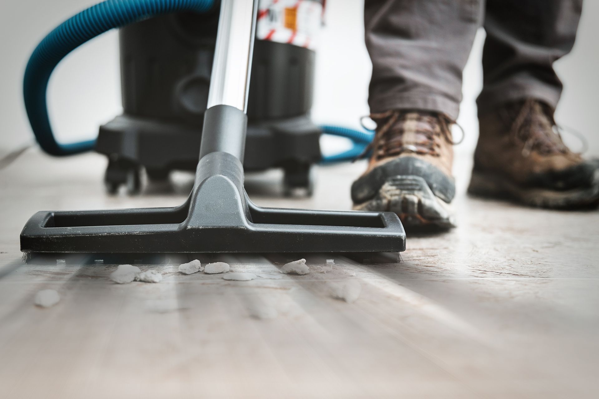 A Person Is Using a Vacuum Cleaner to Clean the Floor with Rocks