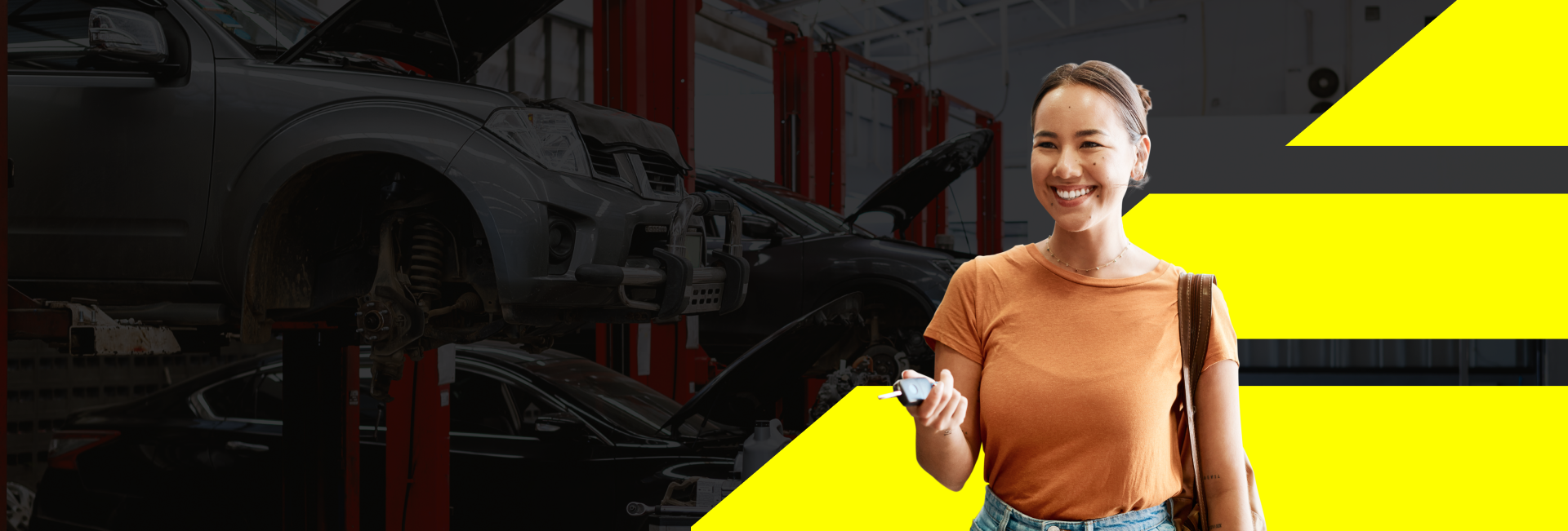 A woman is standing in front of a car in a garage holding a cell phone. | Wagamon Brothers