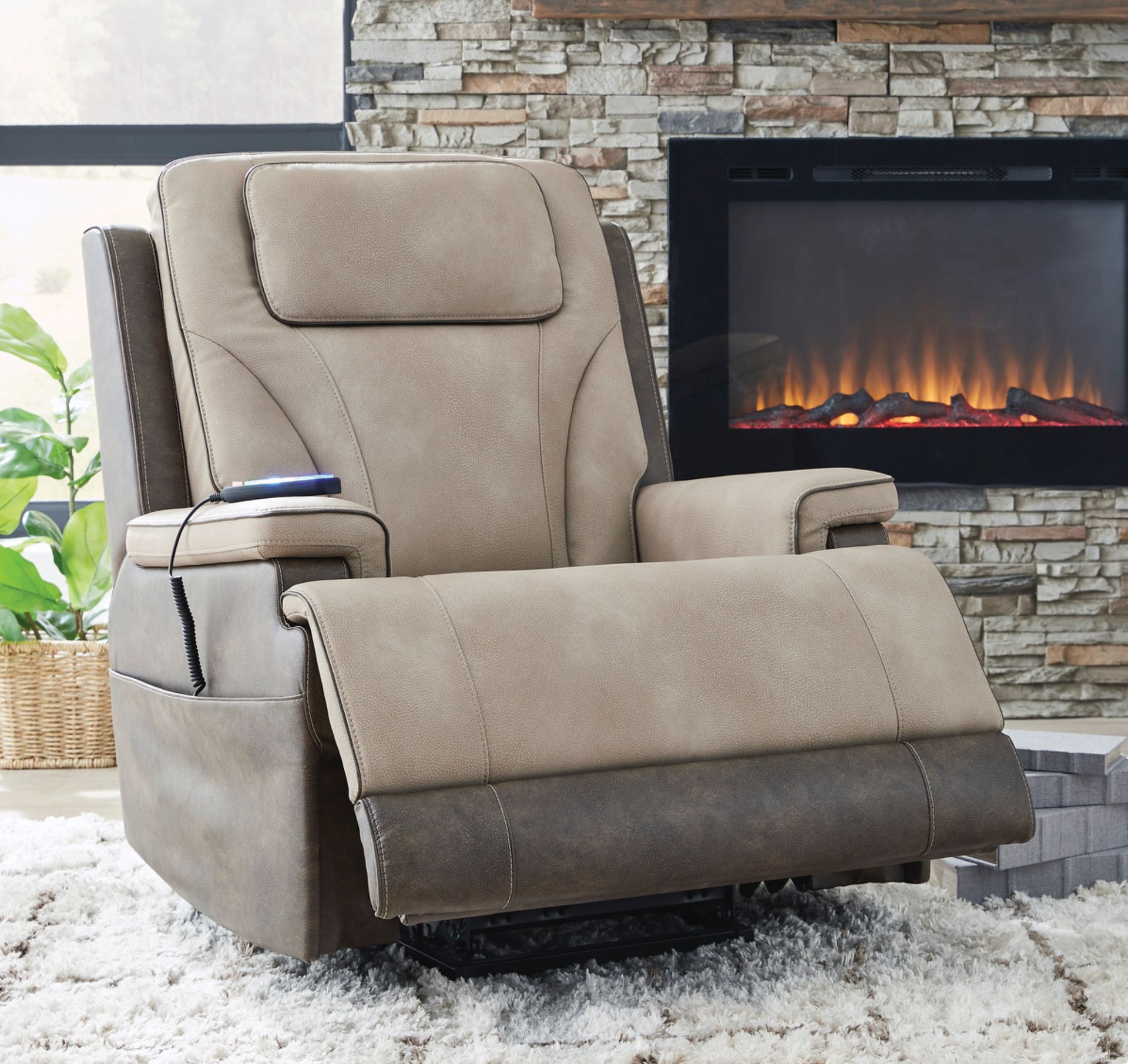 Tan and brown upholstered recliner with a headrest and remote, in front of a fireplace.