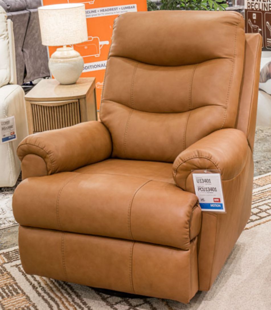 Tan leather recliner chair in a showroom setting.