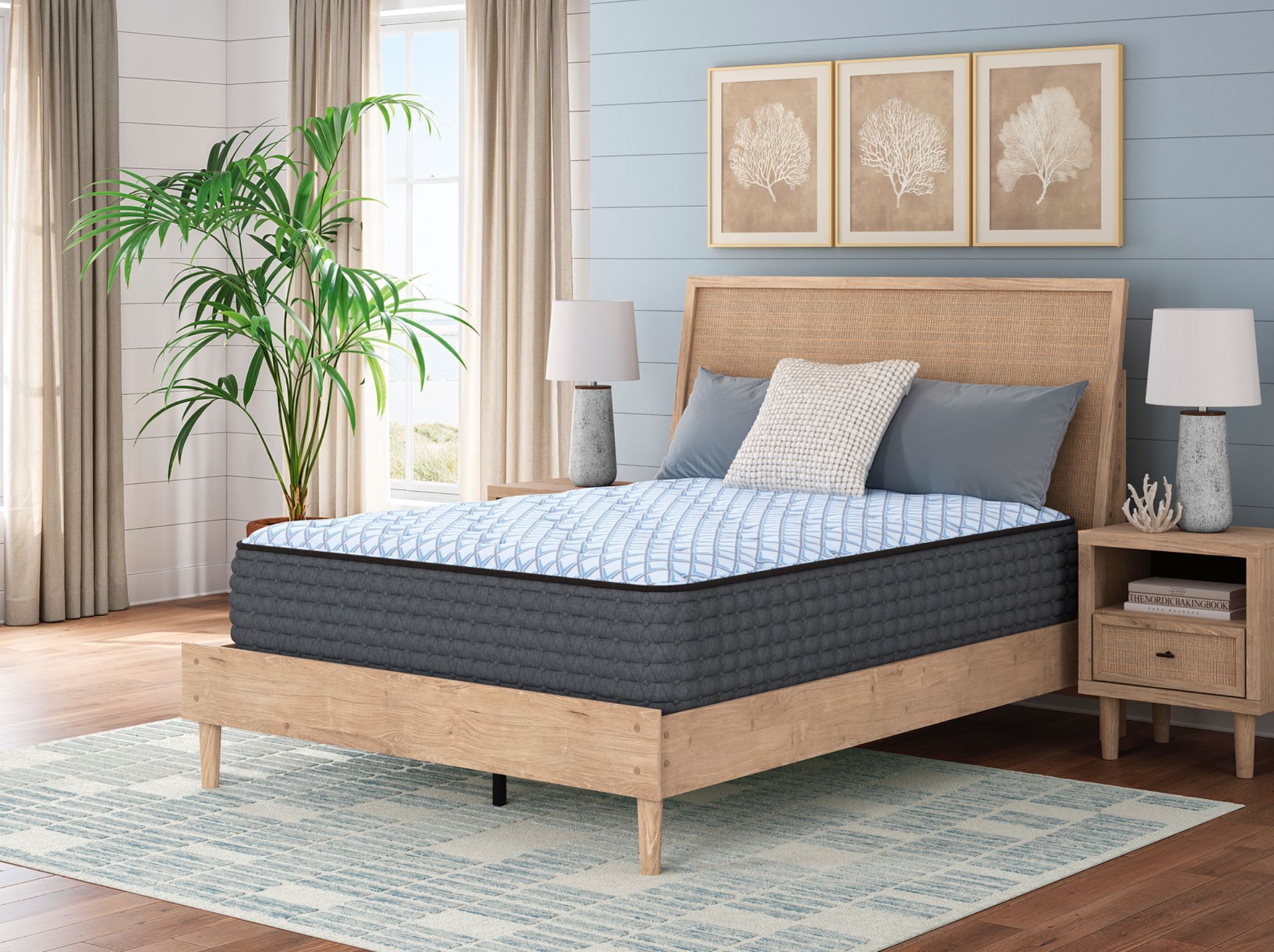 Bedroom with bed, mattress, and blue and white bedding, with plant, window, and wall art.
