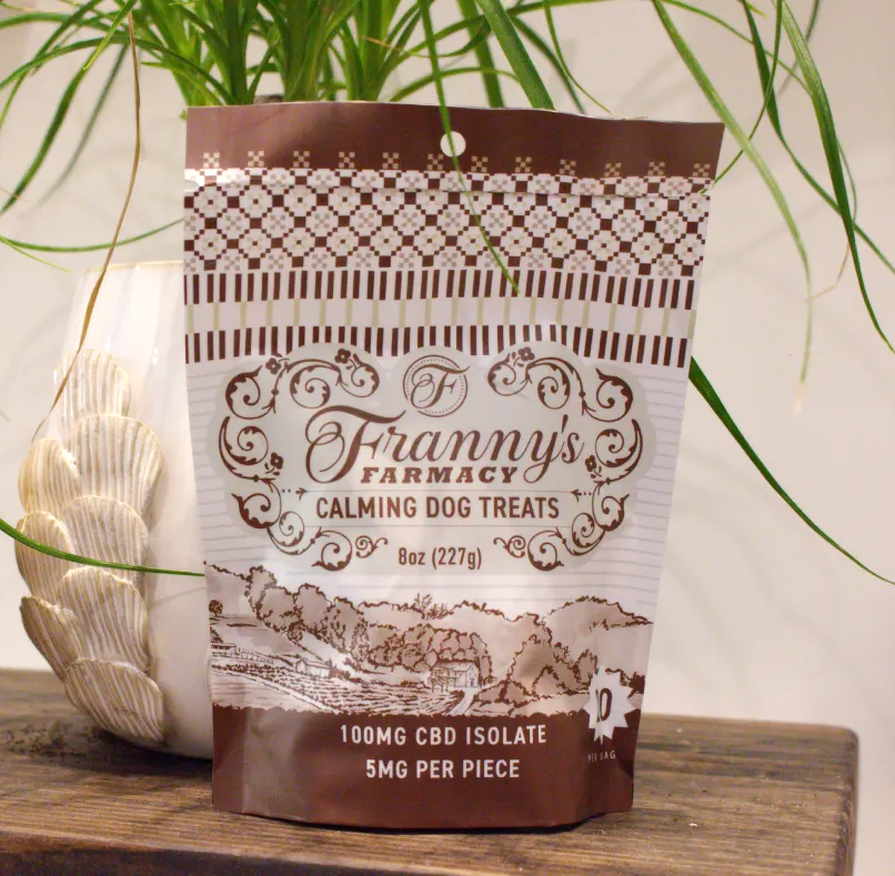 A bag of Franny's Farmacy calming CBD dog treats in front of a green plant 