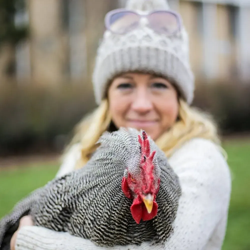 Franny's Farmacy founder holding one of her chickens outdoors on her farm in Asheville, NC