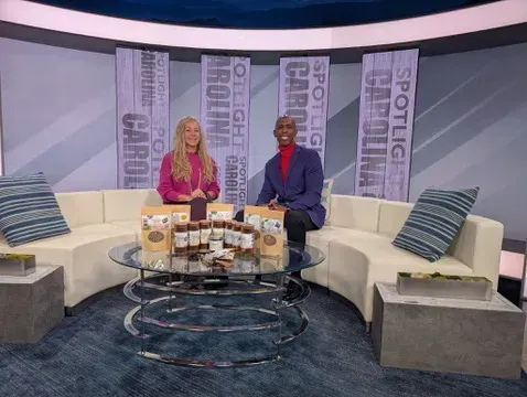 Franny Tacy sitting on a white couch with a news anchor in a TV studio