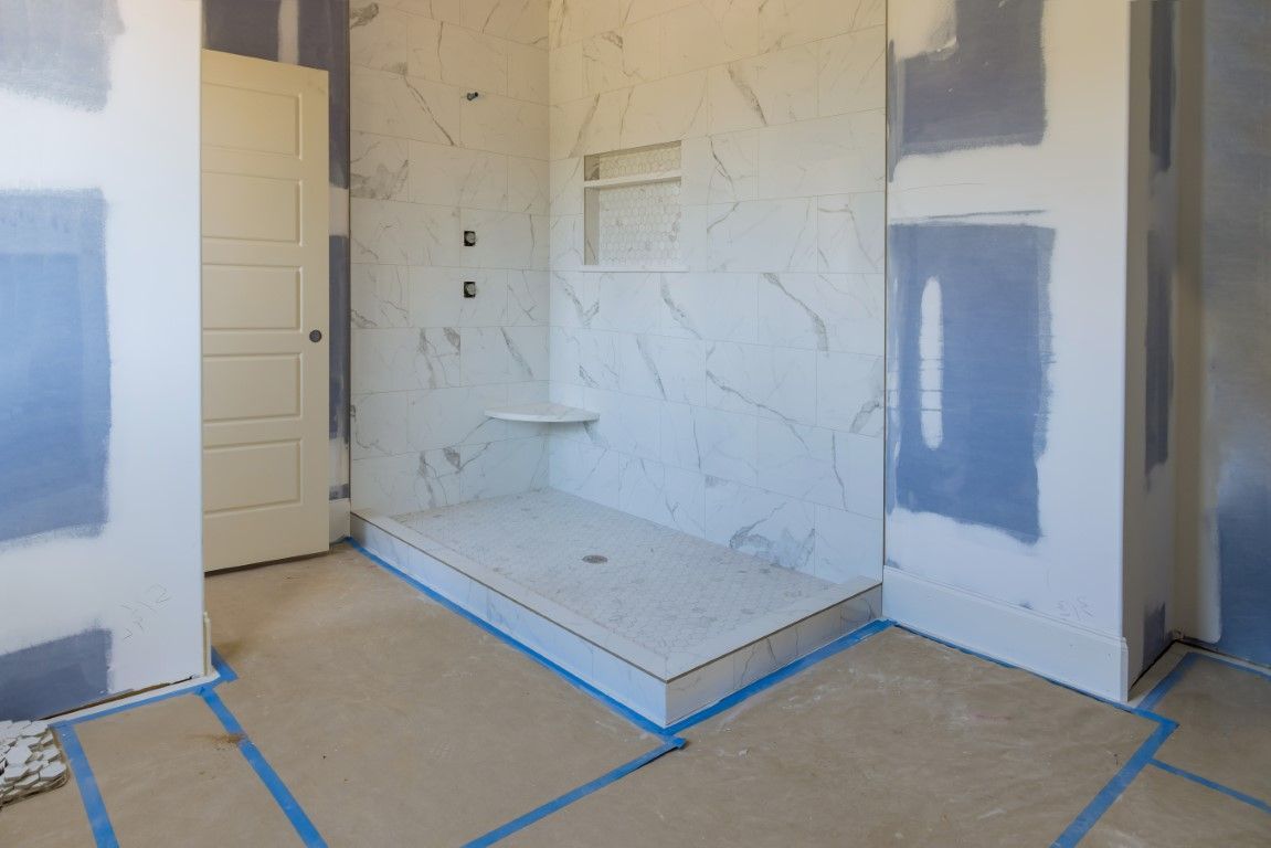 A marbled open shower mid-construction