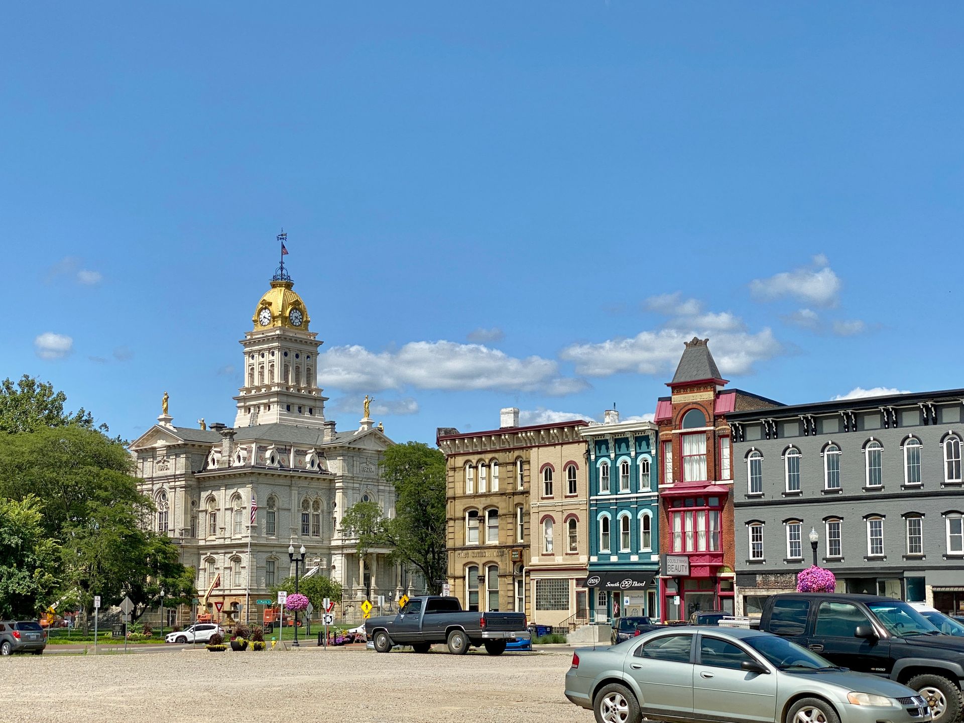 A row of buildings with cars parked in front of them.