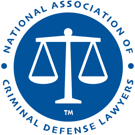 Logo for the National Association of Criminal Defense Lawyers, featuring a white scale of justice inside a blue circle.
