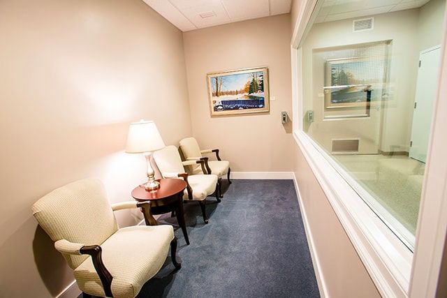 a waiting room with chairs , a table and a window .