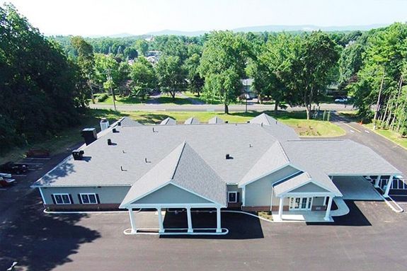 an aerial view of a large house surrounded by trees and a road .