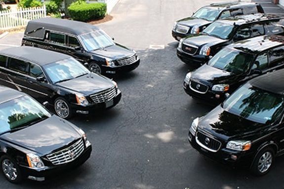 a group of black cars are parked in a parking lot .
