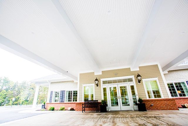 a large house with a covered porch and a bench in front of it .
