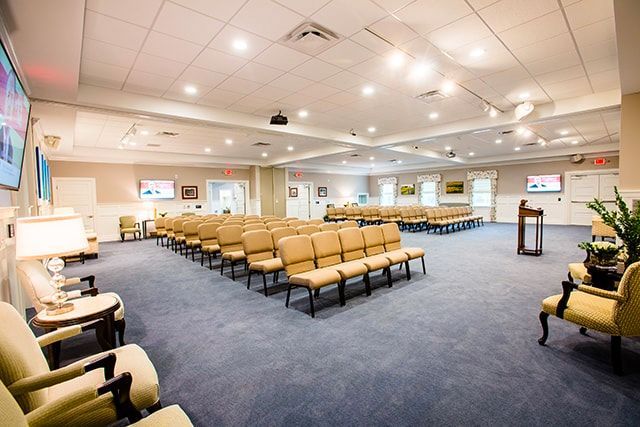 a large room with rows of chairs and a podium .