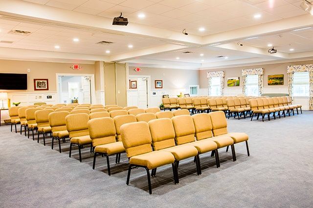 a large room filled with rows of chairs and a projector .