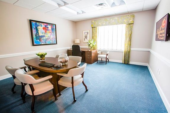 a conference room with a table and chairs and a desk .