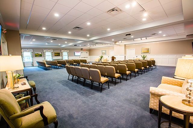 a large room with rows of chairs and tables in a church .