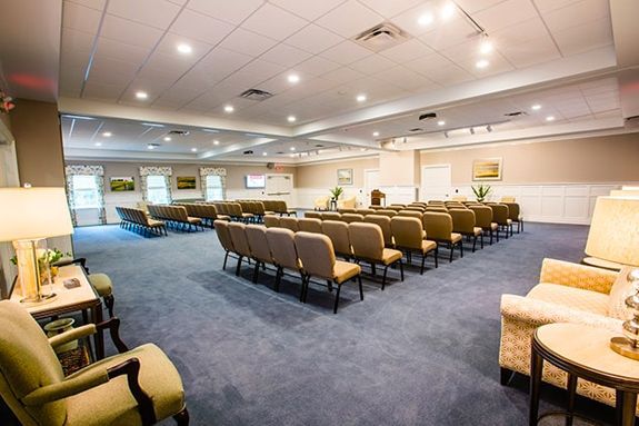 a large room with rows of chairs and tables in it .