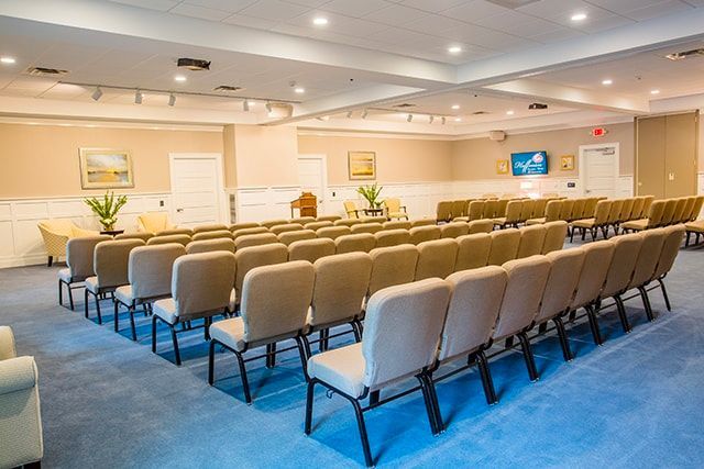 a large room filled with rows of chairs and a podium .