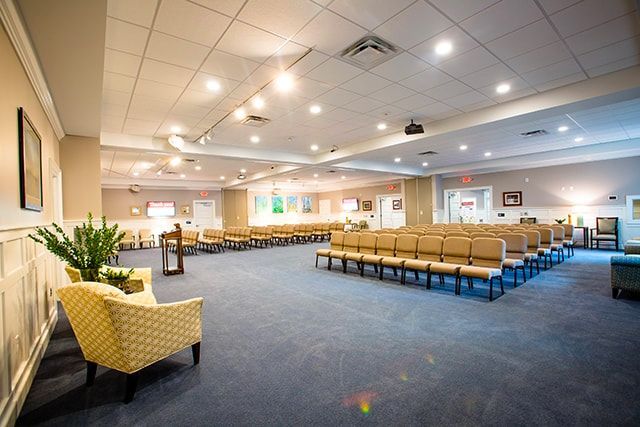 a large room with rows of chairs and a projector on the ceiling .