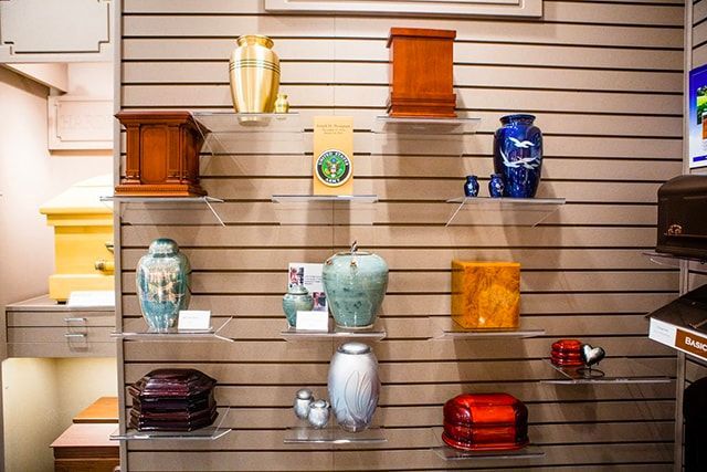 a display of urns and vases on shelves in a funeral home .