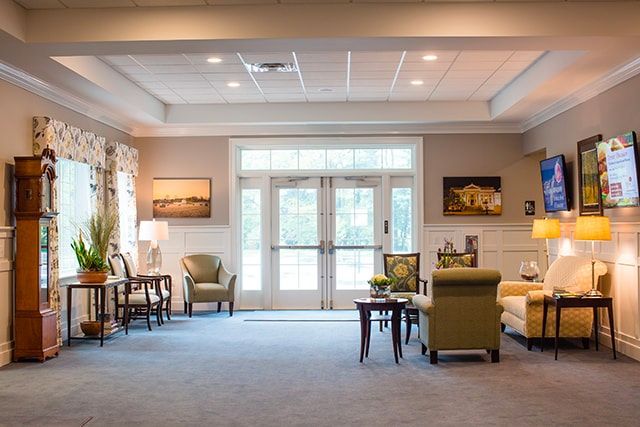 a living room with a couch , chairs , tables and a clock .