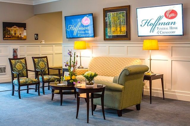 a living room with a couch , chairs , tables and a sign that says hoffman funeral home & crematory