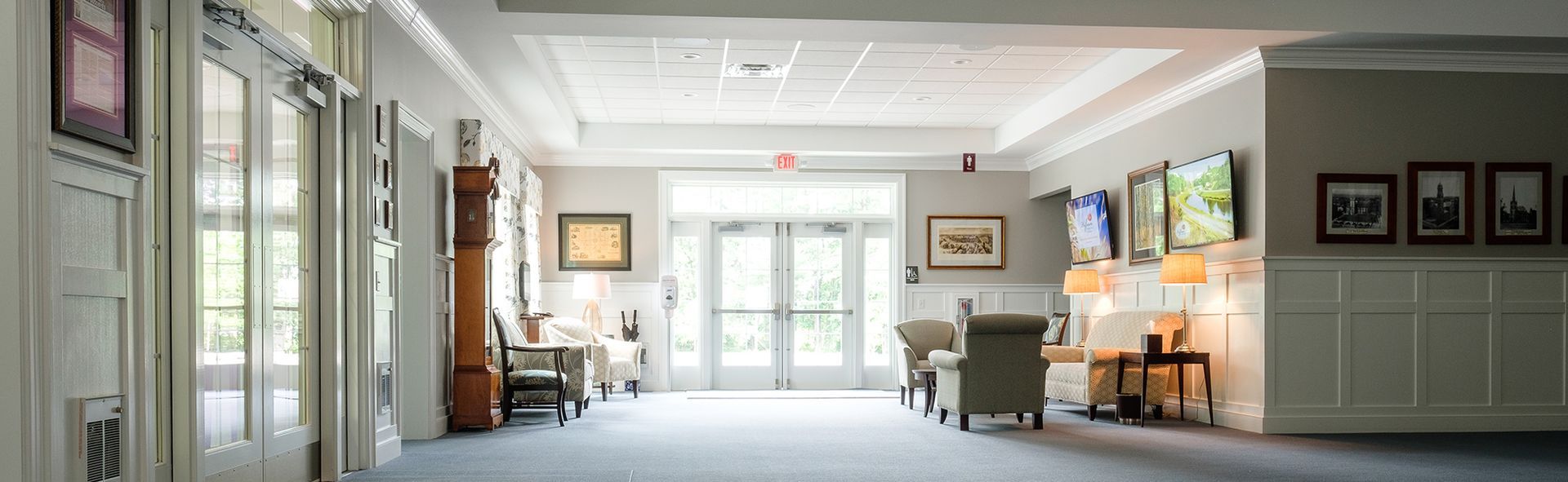 a hallway with a red exit sign on the ceiling