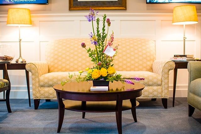 a living room with a couch and a coffee table with flowers on it .