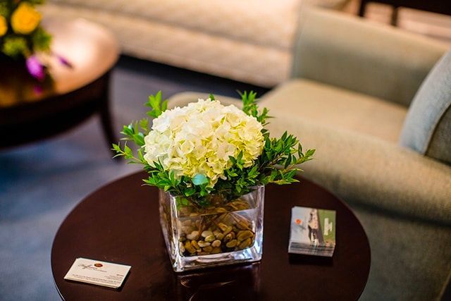 a vase of flowers is sitting on a table next to a chair .