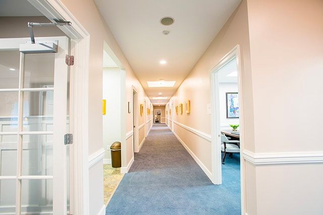 a long hallway in a building with a trash can in the middle .