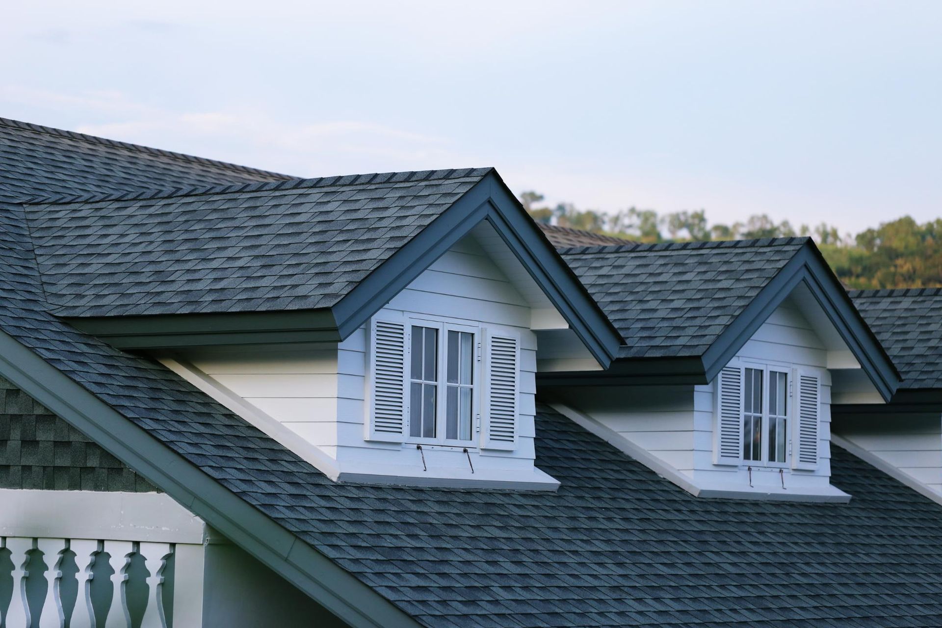 The roof of a house with two windows on it.