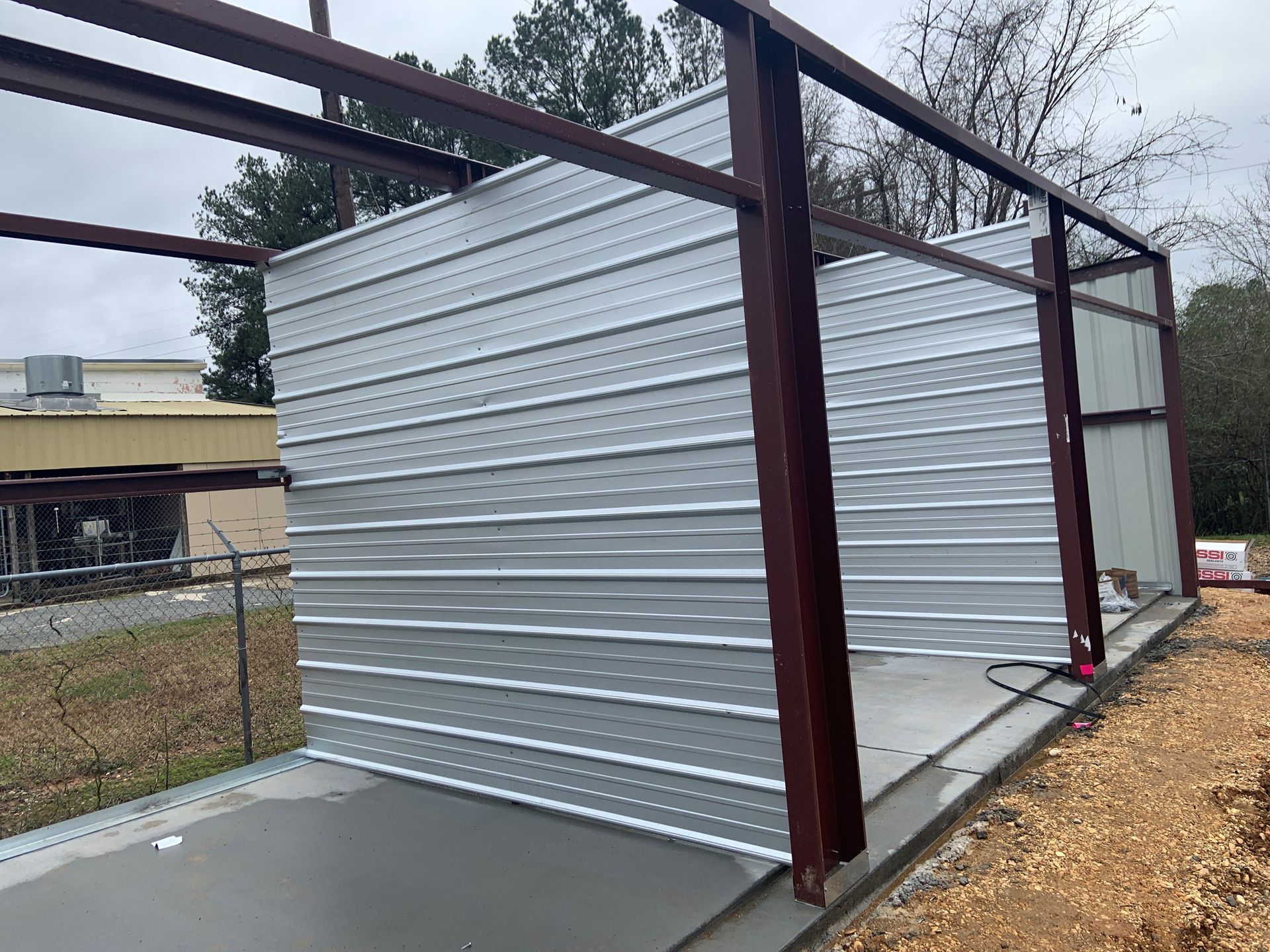 A metal structure is being built in a field.