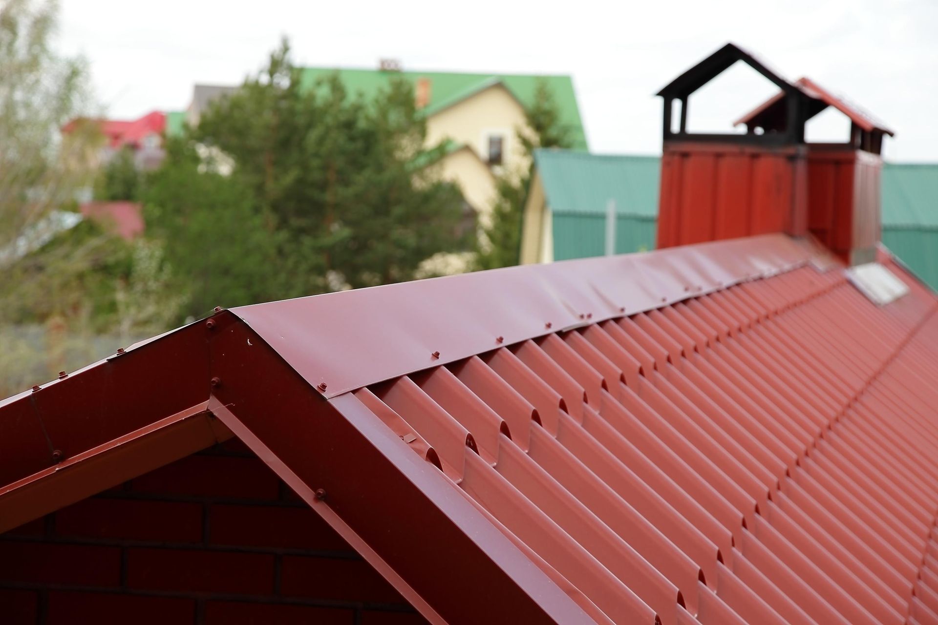 A red roof with a chimney on top of it.