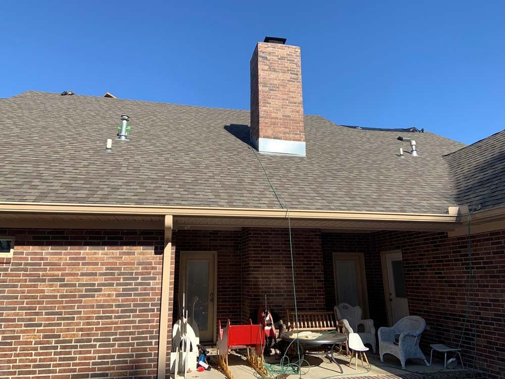 A brick house with a chimney on the roof.