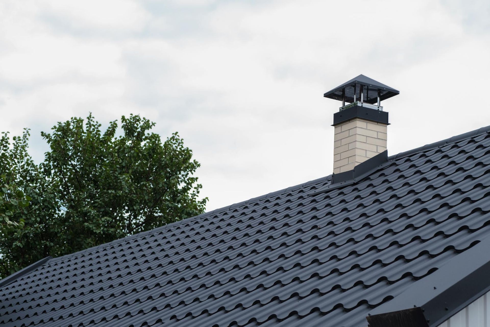 A black roof with a chimney on top of it.