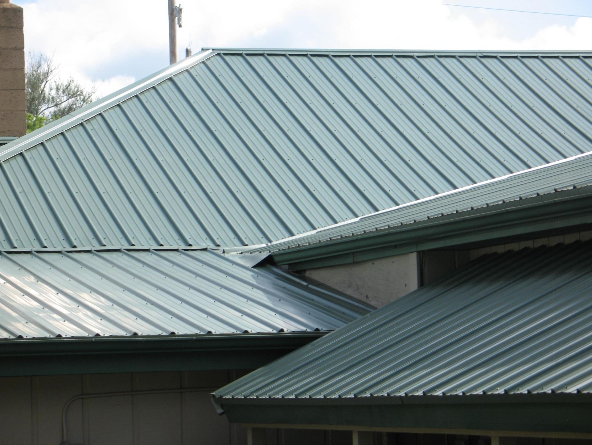 A close up of a green metal roof on a house.