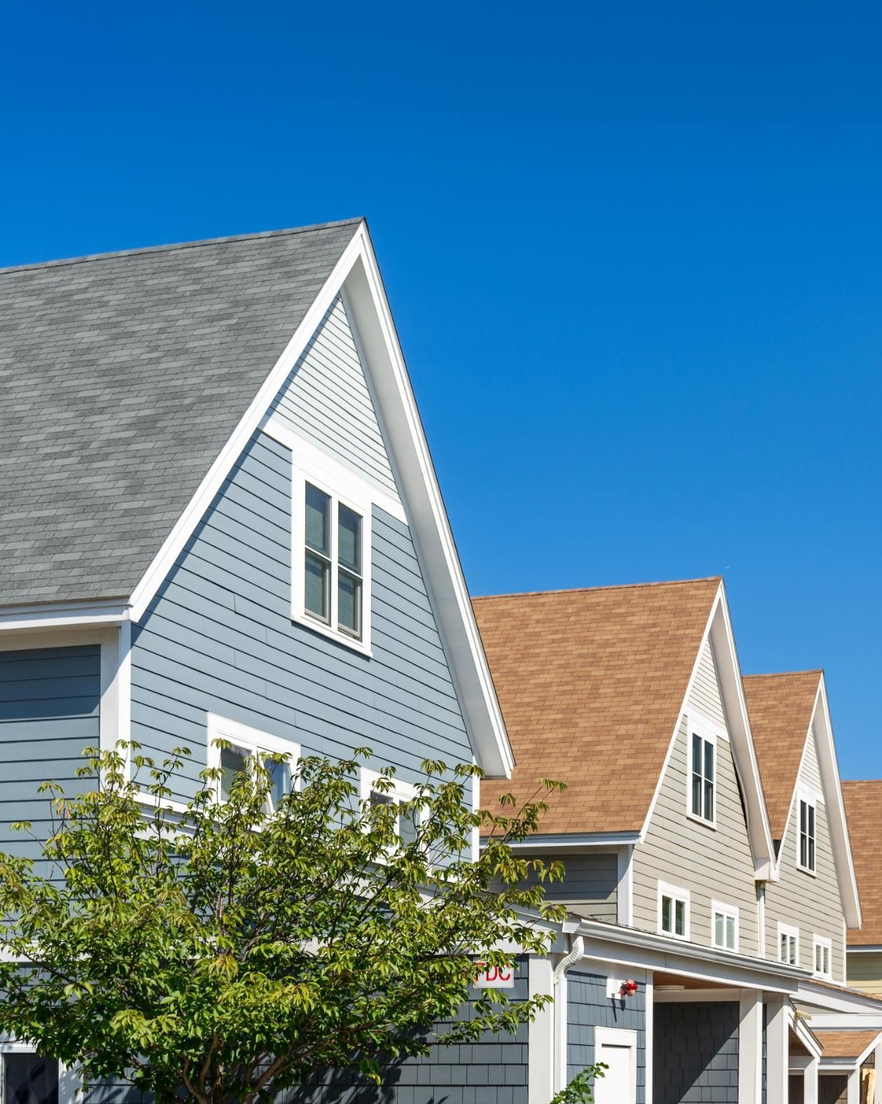 A row of houses with a blue sky in the background.