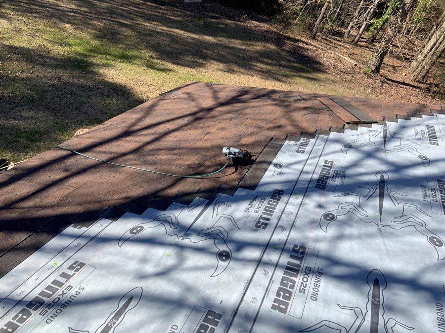 A roof is being installed on a house in the woods.