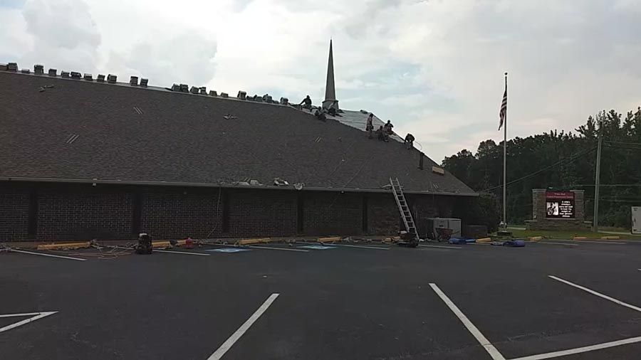 A roof is being installed on a building in a parking lot.