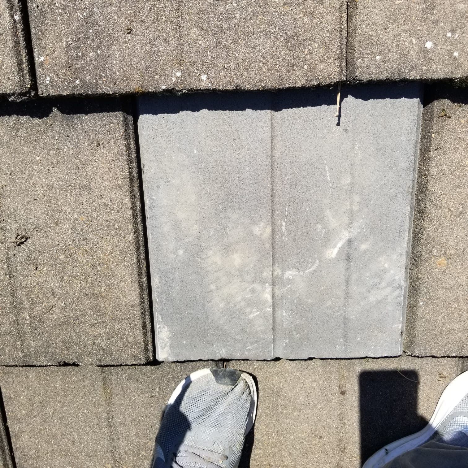 A person is standing on a roof with a hole in it.