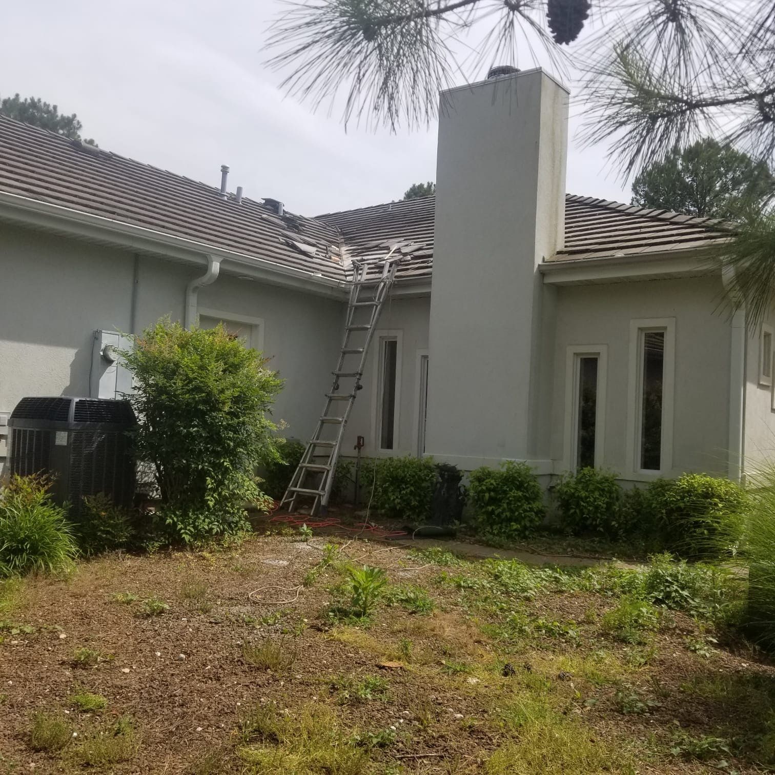 A white house with a ladder on the side of it.