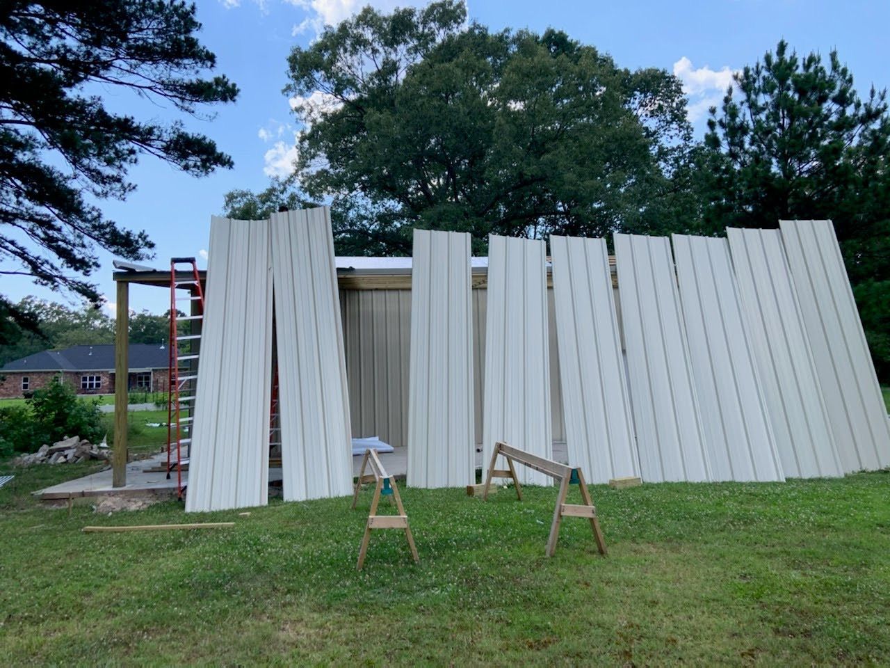 A large stack of white boards is sitting in a grassy field.