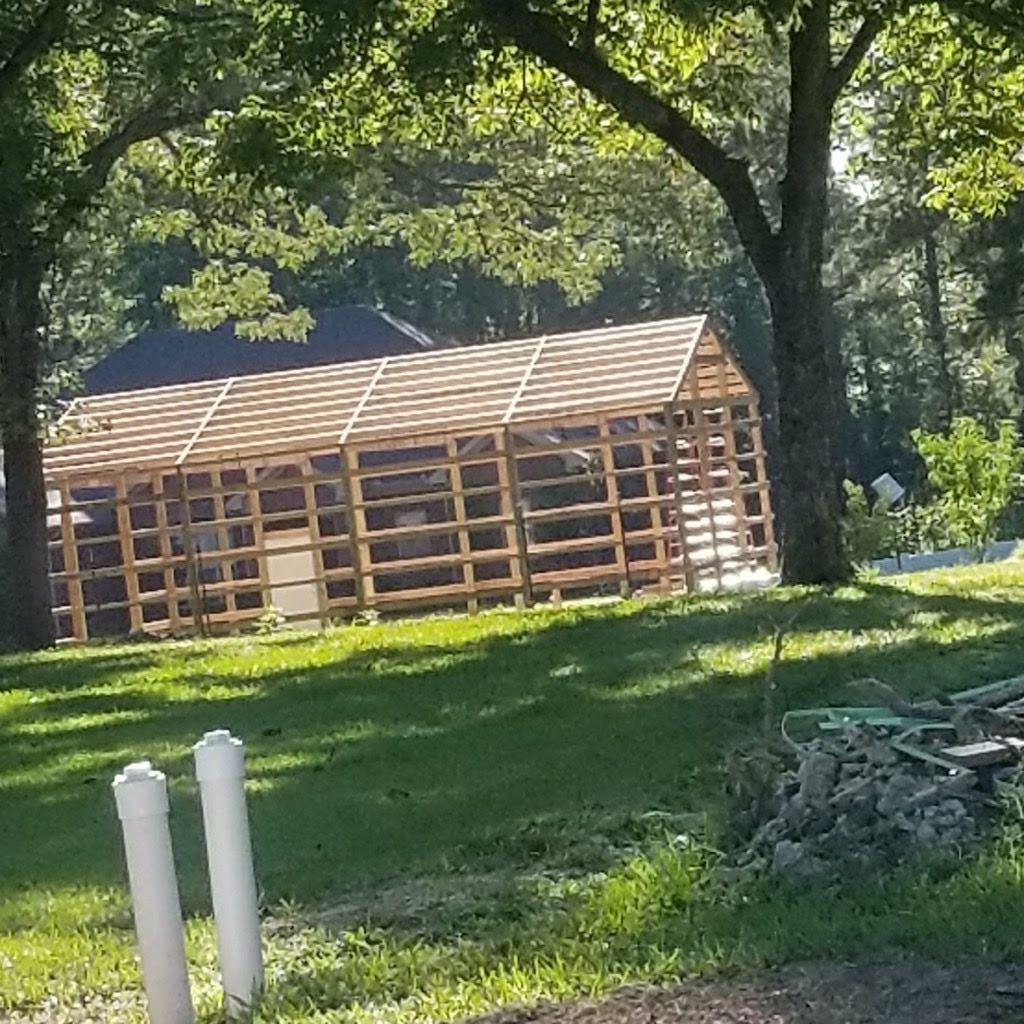 A wooden structure is being built in the middle of a lush green field.