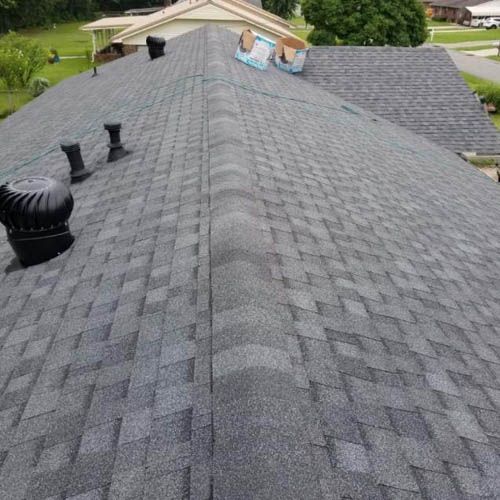 A roof with a lot of shingles and chimneys on it.