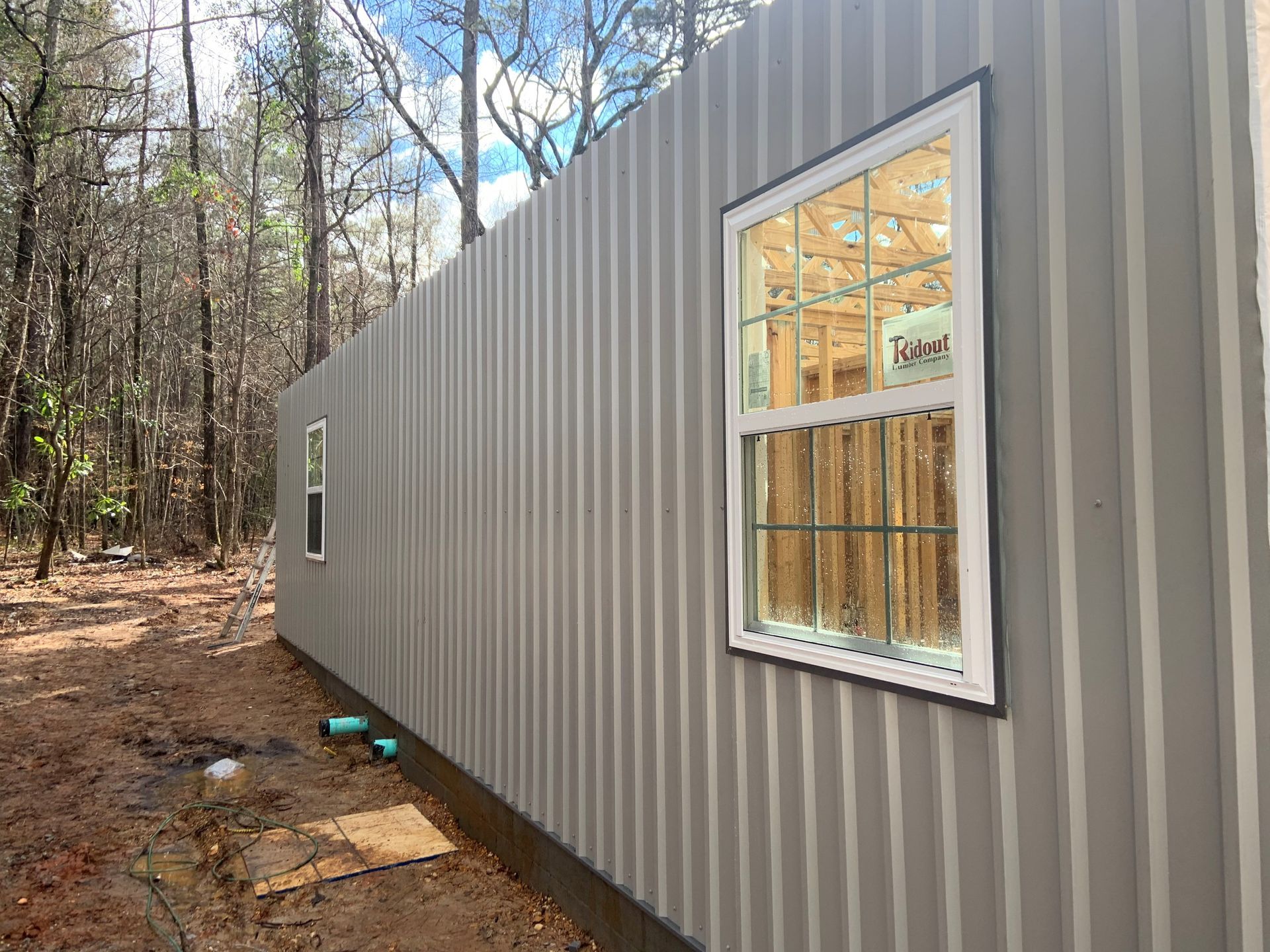 A gray building with a window on the side of it.