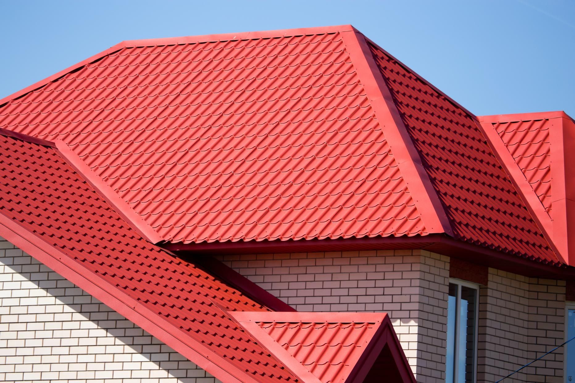 A red roof on a white brick house.