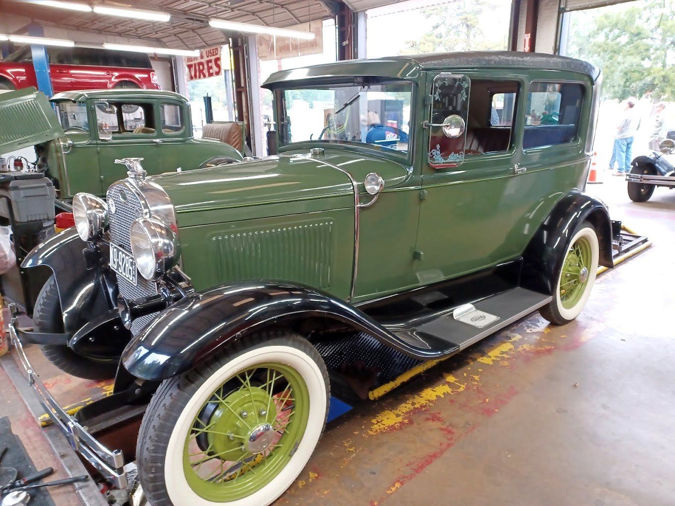 Two cars are parked next to each other in a gravel lot.