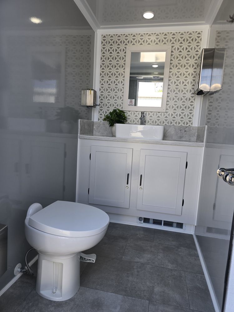 A bathroom with a toilet , sink and mirror.