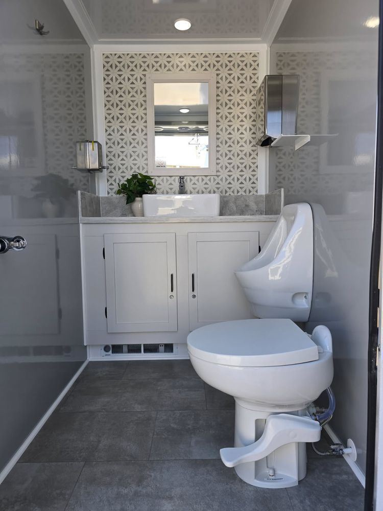 A bathroom with a toilet , sink and urinal.