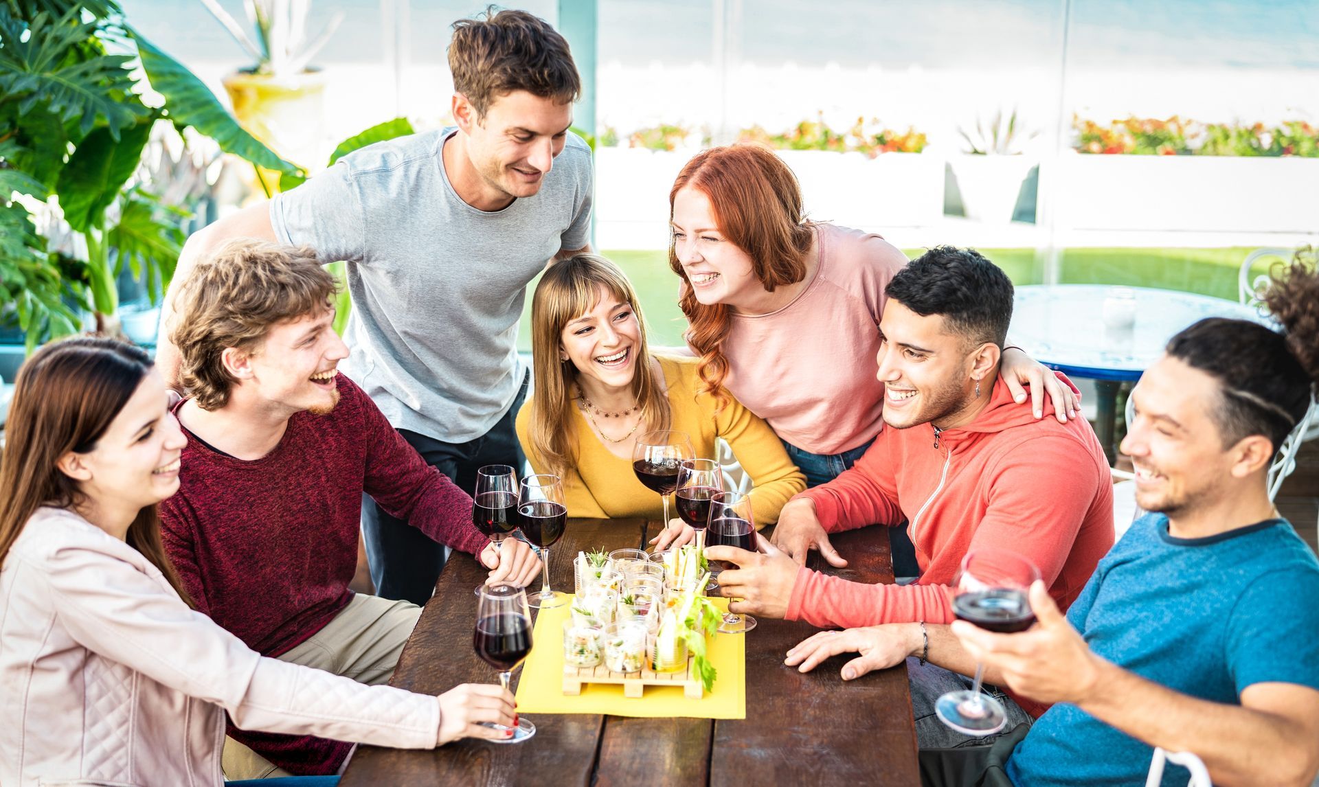 A group of people are sitting around a table drinking wine.