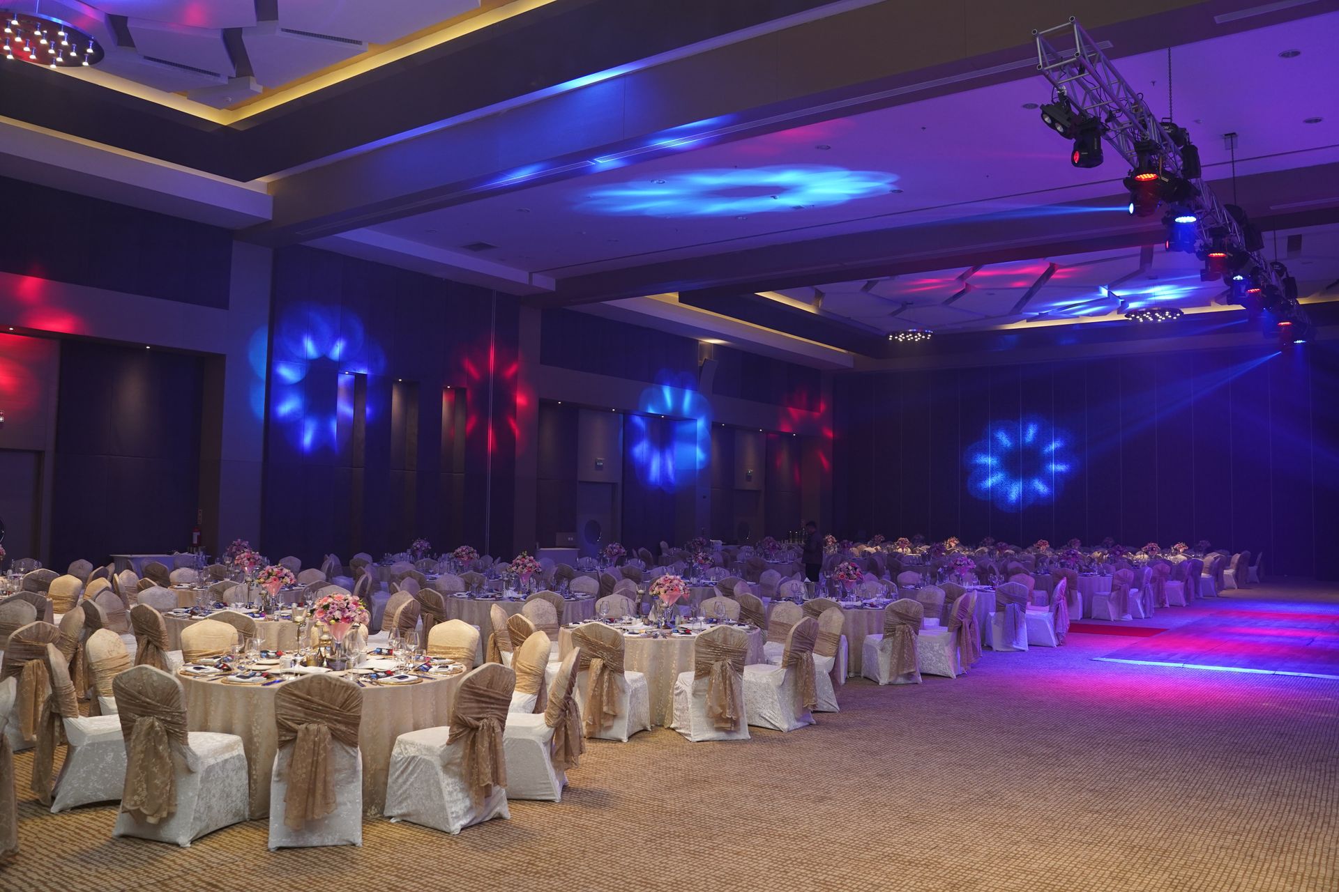 A large ballroom with tables and chairs set up for a wedding reception.